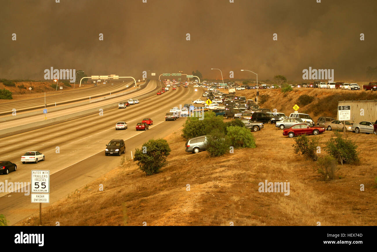 031026-M-3368I-001 Miramar, Californie (oct. 26, 2003) -- Voitures scramble pour quitter l'autoroute par la route jusqu'à la digue à la sur la rampe, et le déplacement de l'écoulement du trafic dans le but de fuir les flammes comme le feu de bois de cèdre traverse la I-15 Freeway sur Marine Corps Air Station Miramar (MCAS). Les multiples incendies ont brûlé plus de 300 000 acres de terre et cet événement catastrophique est considéré comme l'un l'état le plus meurtrier des incendies dans plus d'une décennie. U.S. Marine Corps photo par le sgt Giles M. Isham. (Libéré) feu de bois de cèdre traverse l'Interstate 15 Banque D'Images