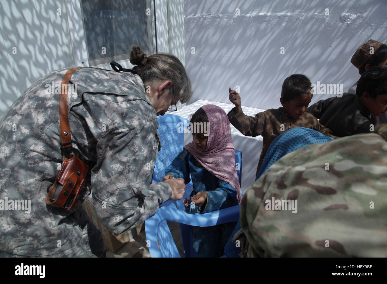 L'arrière de l'US Navy Adm. Martha Herb, chef, secrétariat de l'Accord militaire technique, organe de coordination conjointe, la FIAS aide une petite fille faire un collier de perles au centre de femmes le 5 juin sur la base d'opération avancée Pasab, Afghanistan. Base d'activité Pasab 110605-A-DM450-009 Banque D'Images