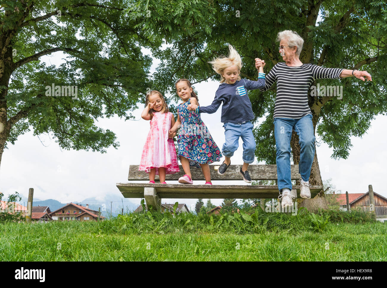 Grand-mère et ses petits-enfants dans l'air passant de banc de parc, Füssen, en Bavière, Allemagne Banque D'Images