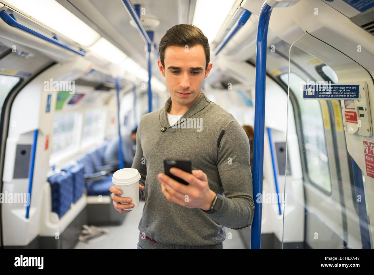 L'Homme du train looking at smartphone Banque D'Images