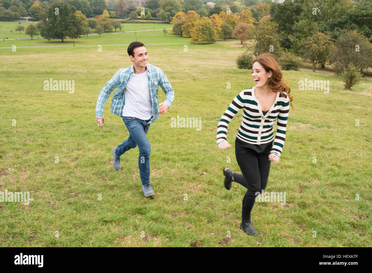 Couple running in field Banque D'Images