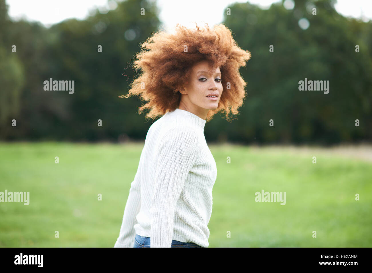 Portrait de curly haired woman looking over Shoulder at camera Banque D'Images
