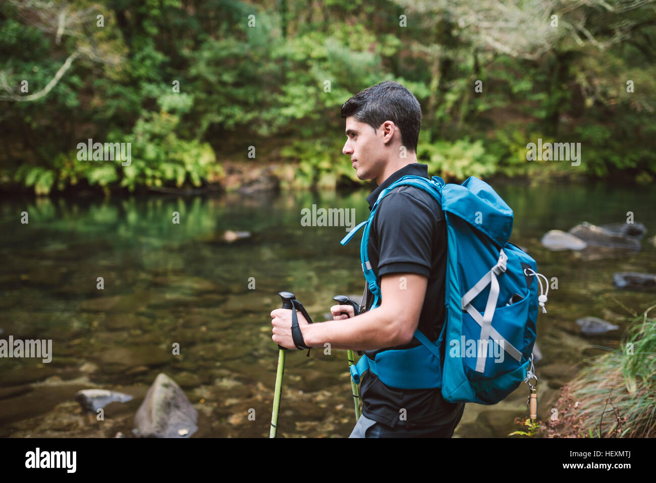 Randonneur debout au bord d'une rivière Banque D'Images