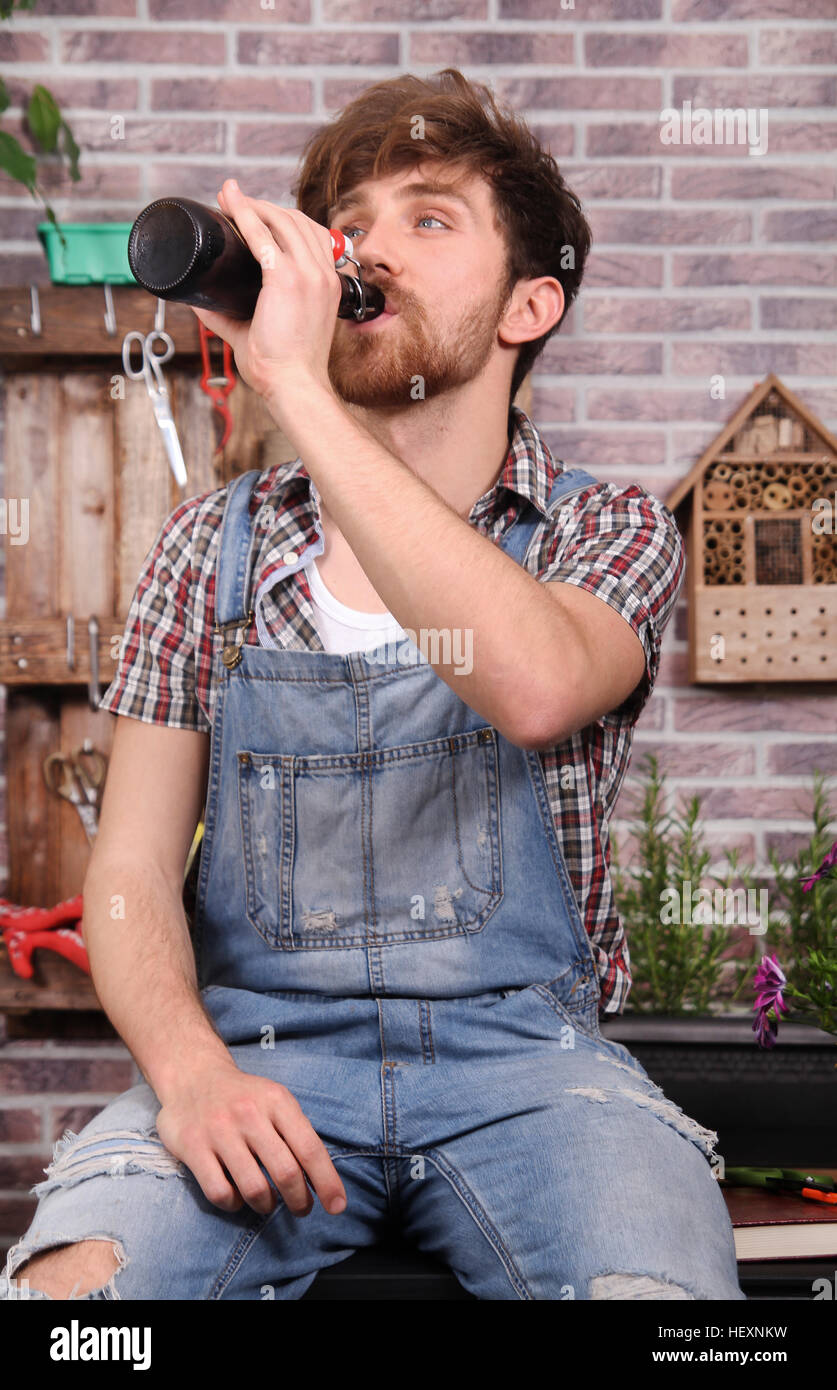 Jeune jardinier en faisant une pause bière potable Banque D'Images