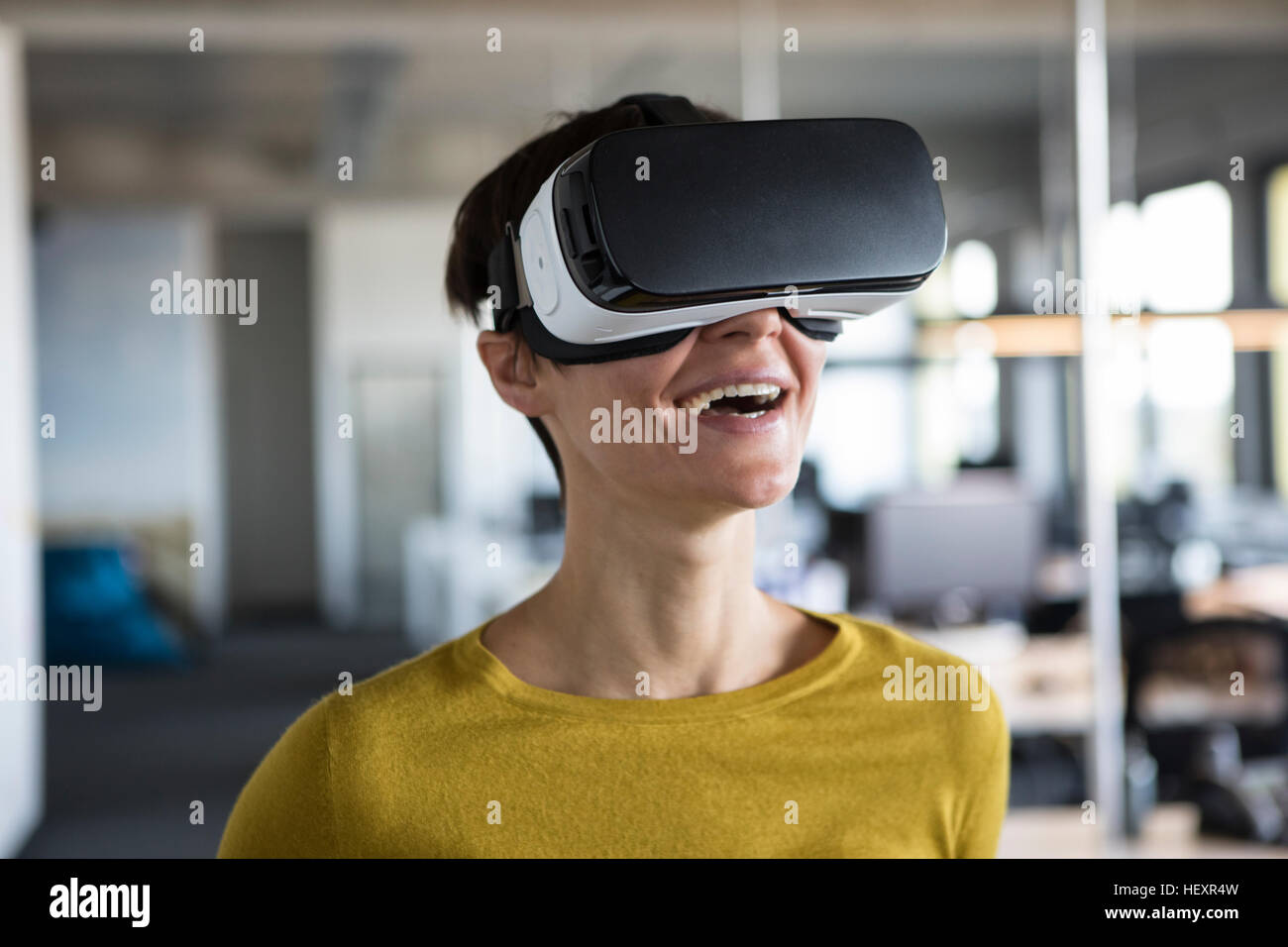 Happy woman in office portant des lunettes de réalité virtuelle Banque D'Images