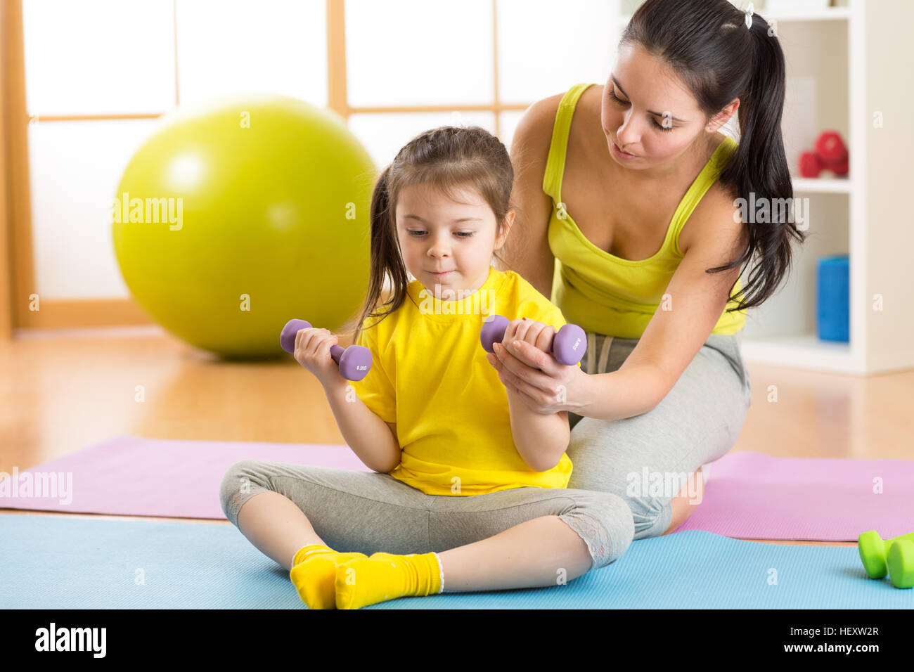 La famille de la mère et enfant fille sont engagés dans fitness, yoga, l'exercice à la maison ou salle de sport Banque D'Images