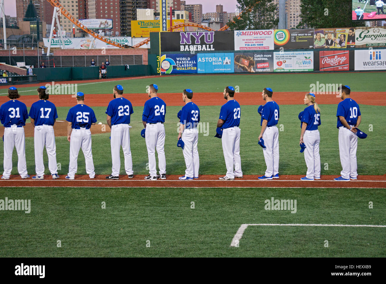 Les hommes et une femme avec l'équipe nationale féminine de stand avec leurs troupeaux couverts pour la lecture d'Hatikva Banque D'Images