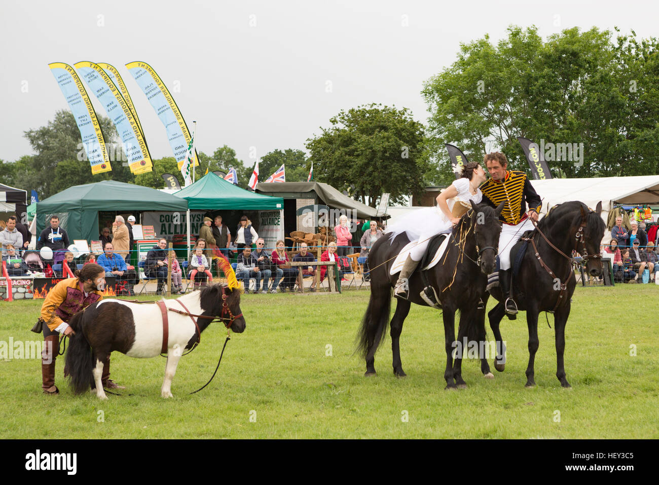 Un homme et des femmes en costume monter à cheval lors d'une exposition à l'événement les trois comtés show, Malvern, Worcestershire, Angleterre. Banque D'Images
