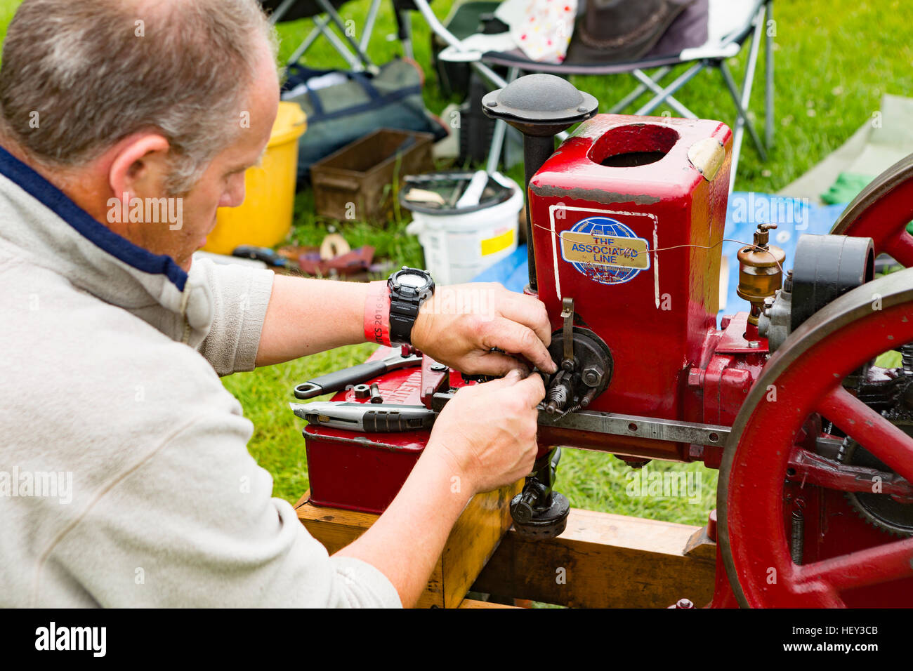 Un homme ajuste un moteur stationnaire à un spectacle. Banque D'Images