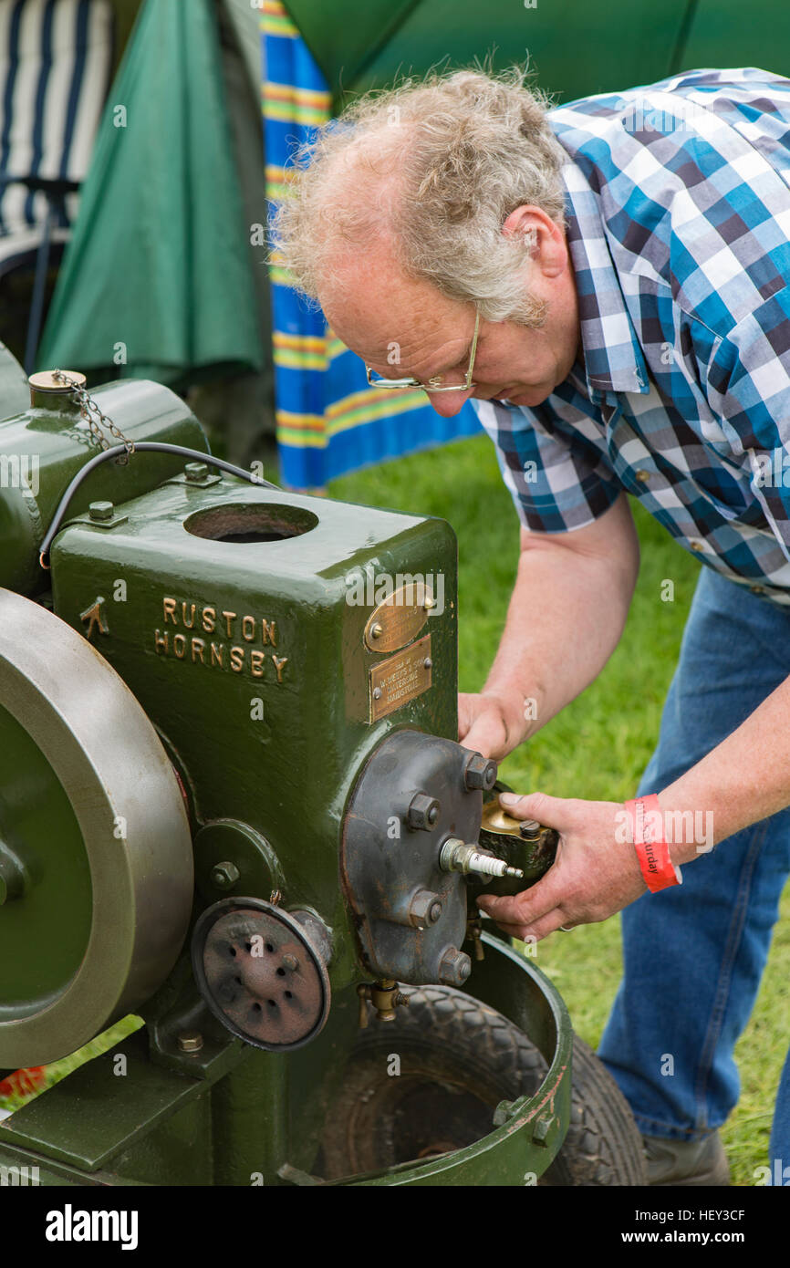 Un homme ajuste un moteur stationnaire à un spectacle. Banque D'Images