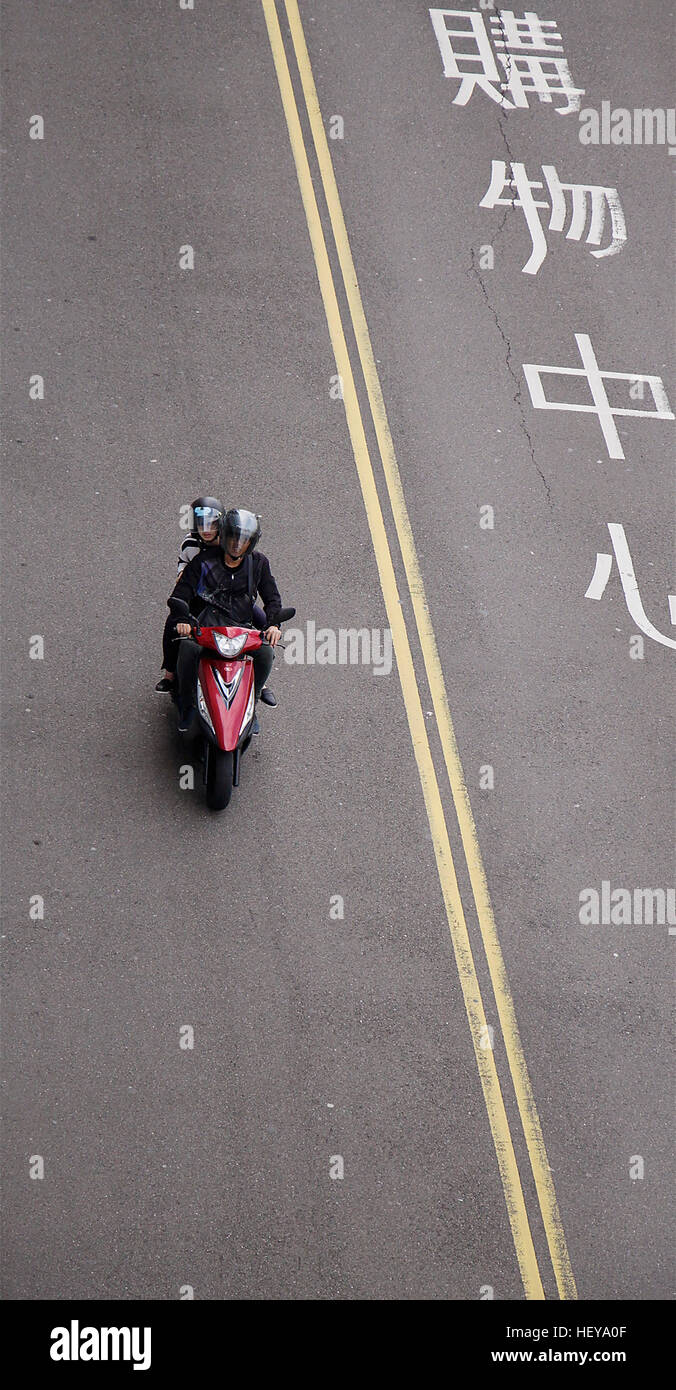 Couple sur un scooter sur la route. Banque D'Images