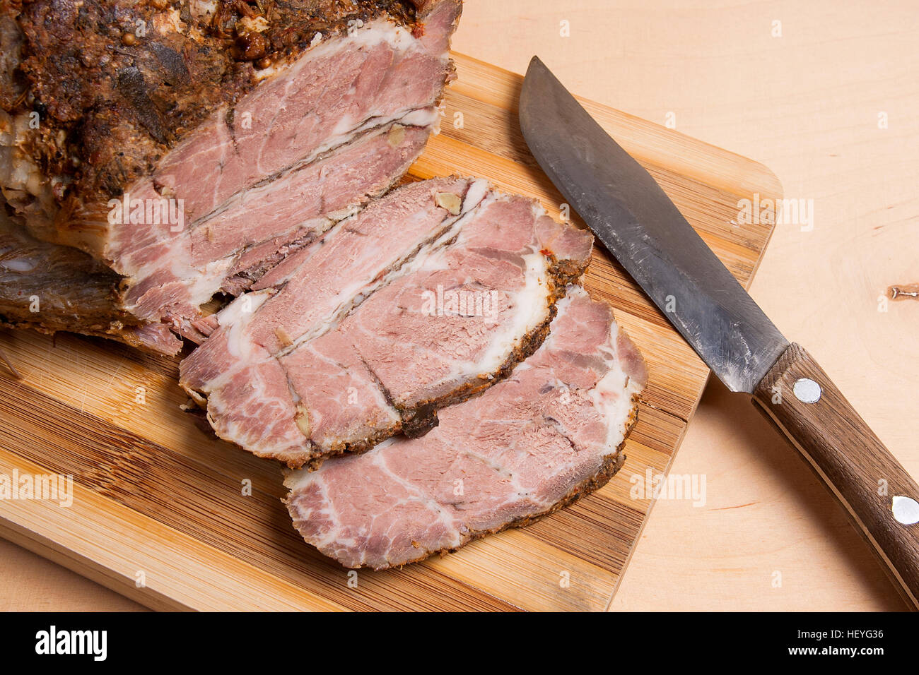 Un porc frais juteux avec des herbes et d'épices sur planche à découper en bois. Meubles de style campagnard jambon épicé au four. Banque D'Images