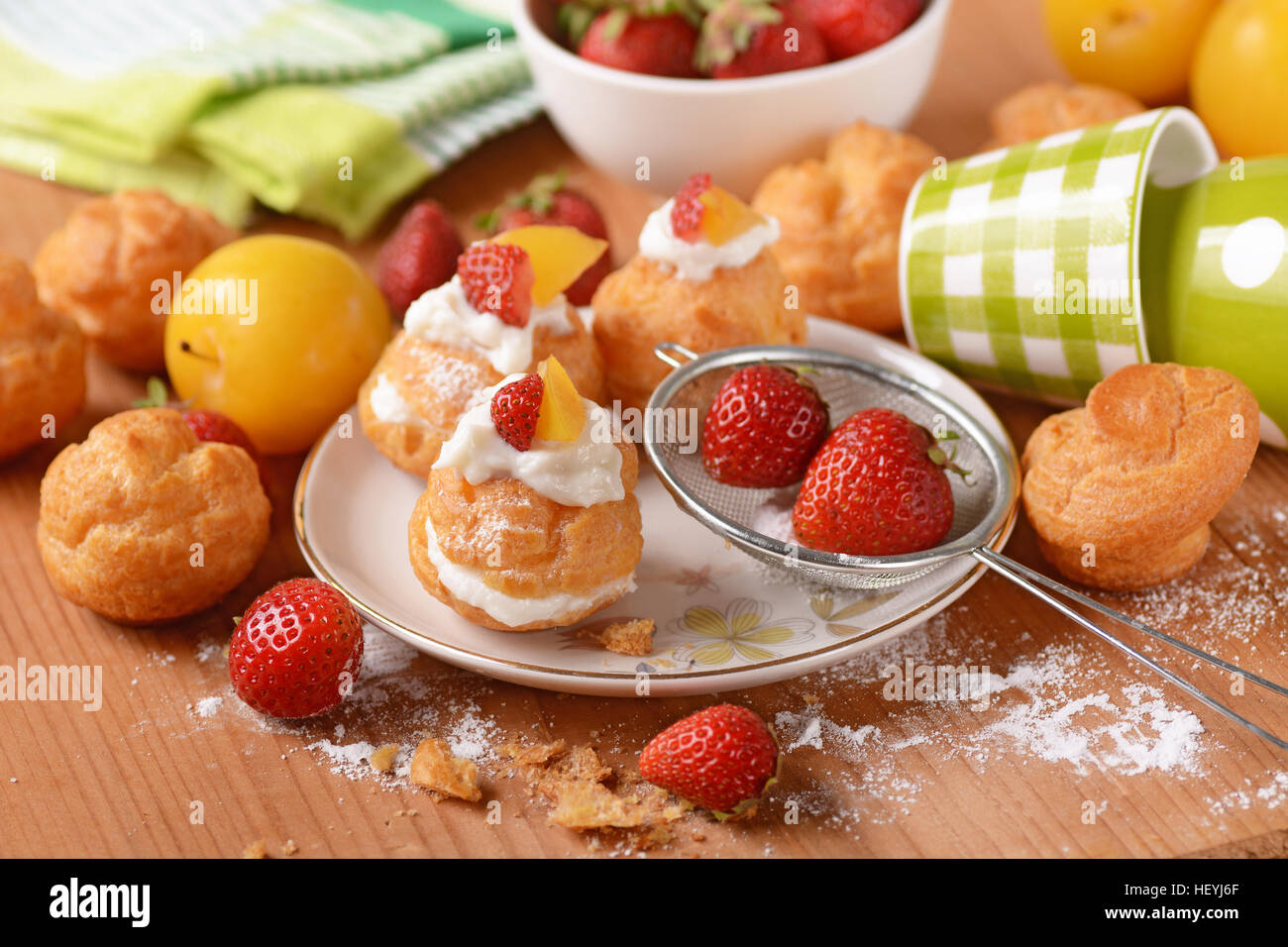 Profiteroles stuffed décoré avec des morceaux de fruits Banque D'Images