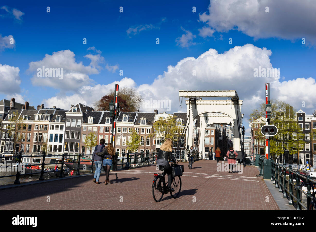 Piétons et cyclistes traversant le Magere Brug pont en bois à Amsterdam, Hollande, Pays-Bas. Banque D'Images