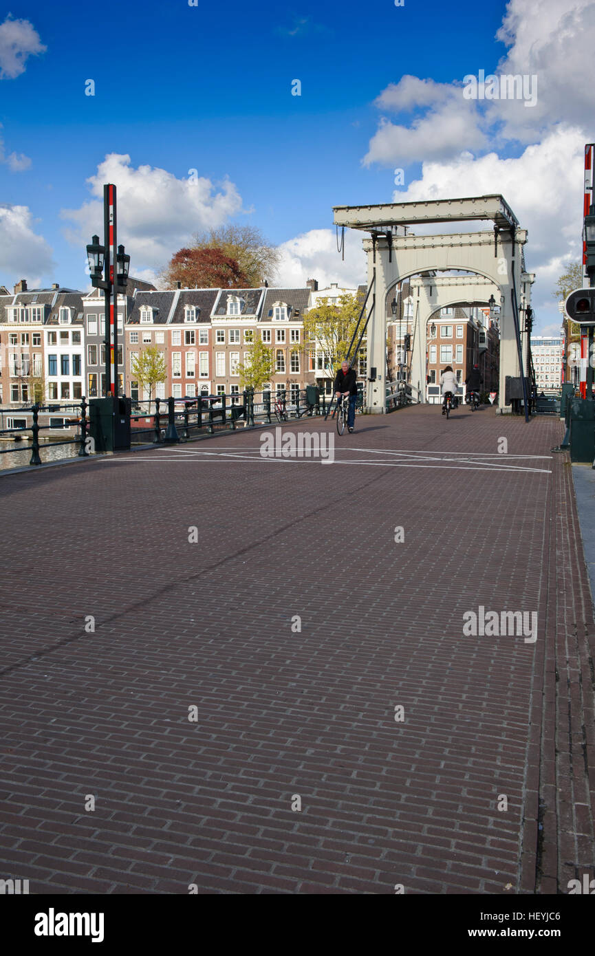 Piétons et cyclistes traversant le Magere Brug pont en bois à Amsterdam, Hollande, Pays-Bas. Banque D'Images