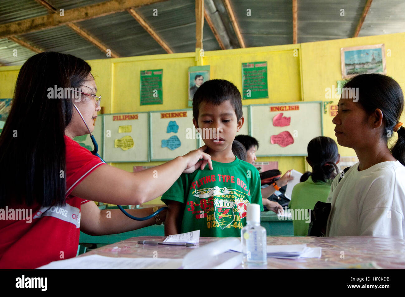 Le Dr Mary Ann Navarro, un agent de santé provincial à Palawan Provence, vérifier les poumons d'un jeune garçon à l'école primaire de Quinlogan, Palawan, Philippines, le 22 octobre 2011. Certains des services offerts par philippine et de la marine Médecins et dentistes, et les médecins étaient provisoires civiles ; consultations, circoncision, examen dentaire et les extractions de dents. L'action civile médicale et dentaire en Philbex 2012 projet. (U.S. Marine Corps photo par le Cpl. Patricia D. Lockhart/libérés) Mary Ann Navarro, un agent de santé provincial à Palawan Provence, vérifier les poumons d'un jeune garçon à Quinlogan Elementa Banque D'Images