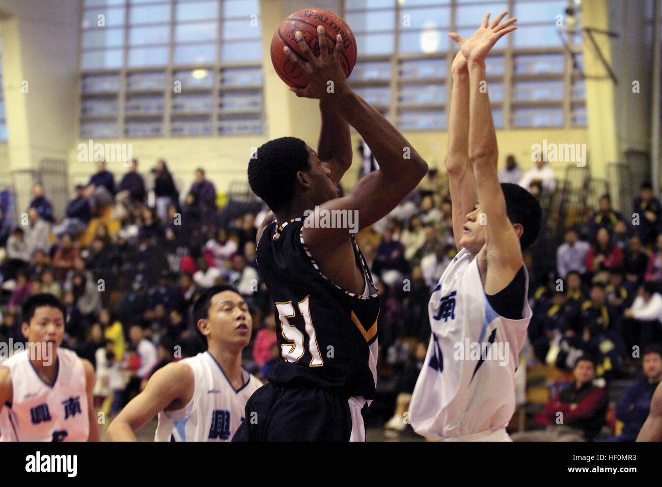 L'équipe de basket-ball garçons Panthers Kadena états Preston pousses Harris sur Kazuta Hiyane de Kohan High School durant la partie de championnat qui a conclu le 6e congrès annuel de l'American Okinawan Shootout au Camp Foster Field House le 22 janvier. Les Panthers de Kadena a remporté la victoire sur Kohan High School d'un fini tout à fait fans hors de leurs sièges pour applaudir. Cuisine américaine, les étudiants d'Okinawa dans nom de l'amitié DVIDS514885 Banque D'Images