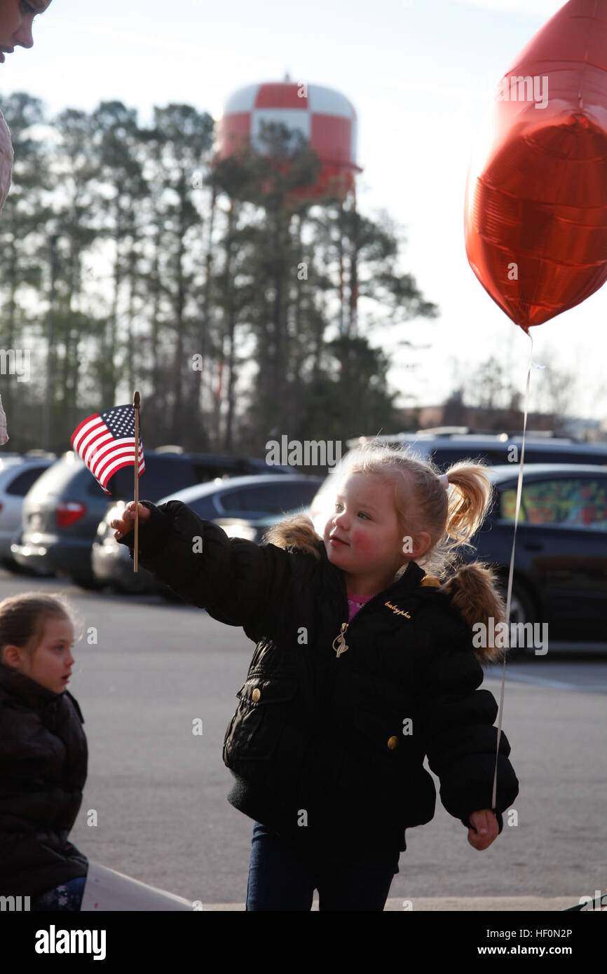 La fille d'un Marine Aviation Escadron logistique 14 vagues marines un petit drapeau américain alors qu'elle attend à l'extérieur du bâtiment de formation et d'éducation pour son père pour revenir après un déploiement de 7 mois au Camp Bastion, l'Afghanistan. La logistique de l'aviation de marine ont été parmi des milliers à se déployer en Afghanistan tout au long de l'année. D'autres marines stationnés ici sont également connectés à force expéditionnaire des marines et des unités déployées dans d'autres régions du monde comme la Corne de l'Afrique. Marine Corps Air Station Cherry Point Bilan de l'année 120203-M-OT671-008 Banque D'Images