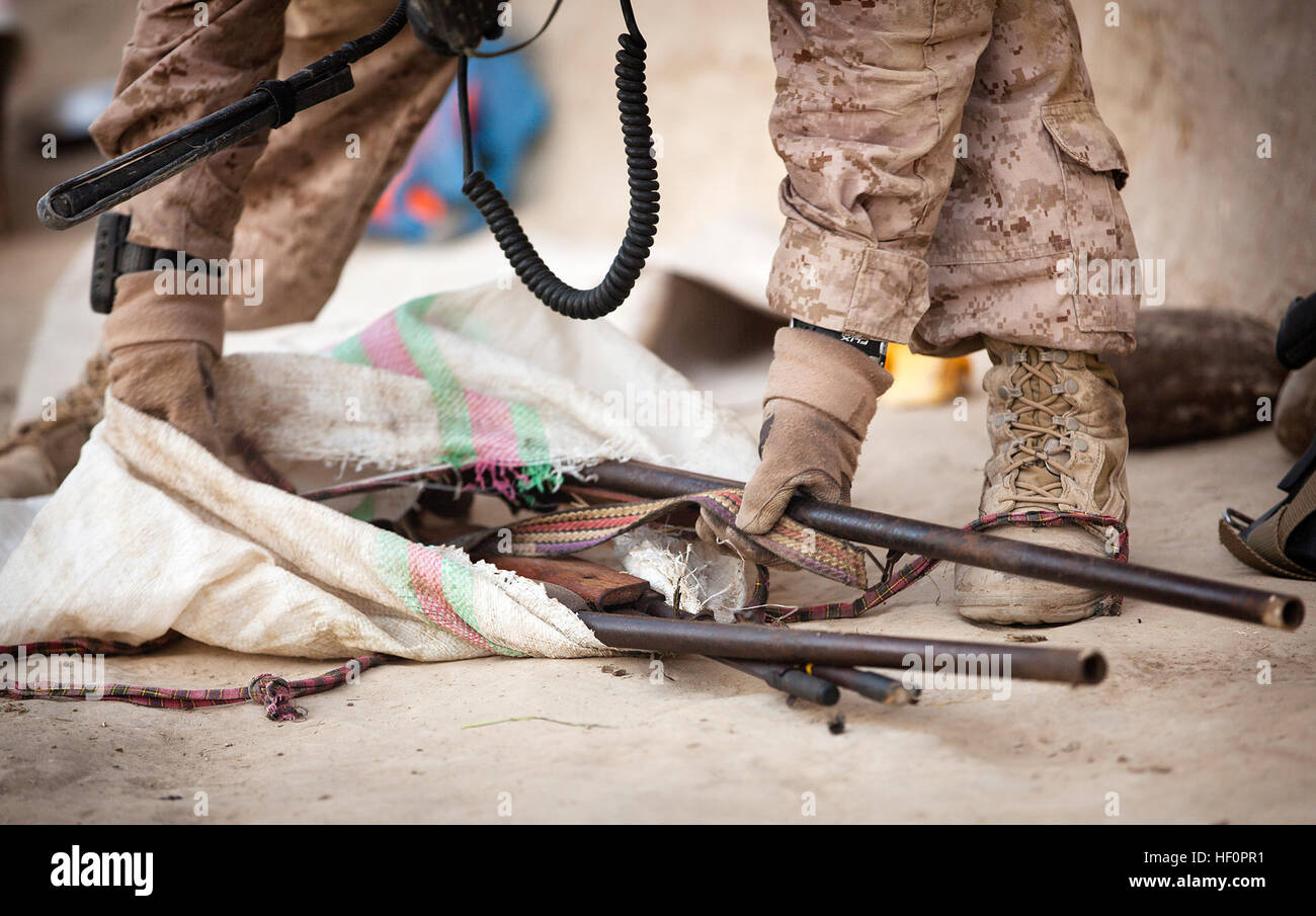 Le Caporal des Marines des États-Unis. Enrique Torres, un chef d'équipe avec le 1er Peloton, la Compagnie Kilo, 3e Bataillon, 3e Régiment de Marines, et un de 21 ans originaire de Burleson, Texas, ouvre un sac contenant des fusils lors de la recherche d'un composé ayant des policiers afghans lors de l'opération SAR Parme Zema Tera (Don't tread on me) ici, le 14 avril 2012. Les forces de sécurité nationale afghanes et 'America' du bataillon de fusiliers marins effectuent une variété de missions dans la province de Helmand, district de Garmsir avant la saison des combats annuel entourant la récolte des cultures illicites de pavot. Nettoyer la maison, la police afghane, Marines rechercher Banque D'Images