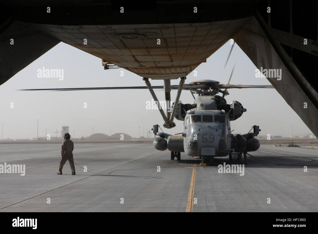 Les Marines américains avec l'Escadron d'hélicoptères lourds Marine (HMH), 361 aéronefs maritimes Groupe 16, 3rd Marine Aircraft Wing (avant), ravitailler un CH-53E Super Stallion à Camp Bastion, dans la province d'Helmand, en Afghanistan, le 29 décembre 2012. HMH-361 prêt à fournir un soutien aérien par le repositionnement de l'obusier M777 au Camp Dwyer. (U.S. Marine Corps photo par le Sgt. Keonaona C. Paulo/libérés) M777 ascenseur extérieur 121229-M-EF955-059 Banque D'Images