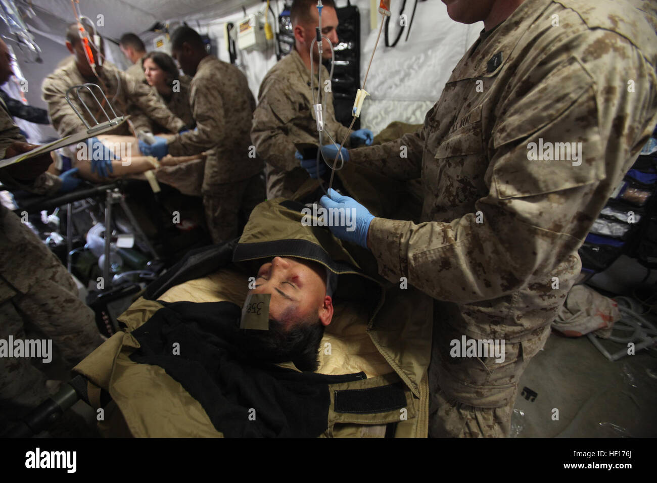 Les médecins et les corpsmen avec le 1er Bataillon Médical, 1er Groupe logistique maritime, ont tendance à la simulation d'un civil blessé la Shock Trauma tente de peloton au cours de l'exercice Black Mamba à bord de Camp Pendleton, en Californie, Mercredi, Mars 27, 2013. Black Mamba a été un exercice de quatre jours qui a mis des Marines et marins dans des conditions rudimentaires et développé en une réponse plus efficace de l'équipe médicale d'urgence. (U.S. Marine Corps photo par le Cpl. Laura Gauna/libérés) 1er Bataillon Médical des trains pour sauver des vies 130327-M-KO203-374 Banque D'Images