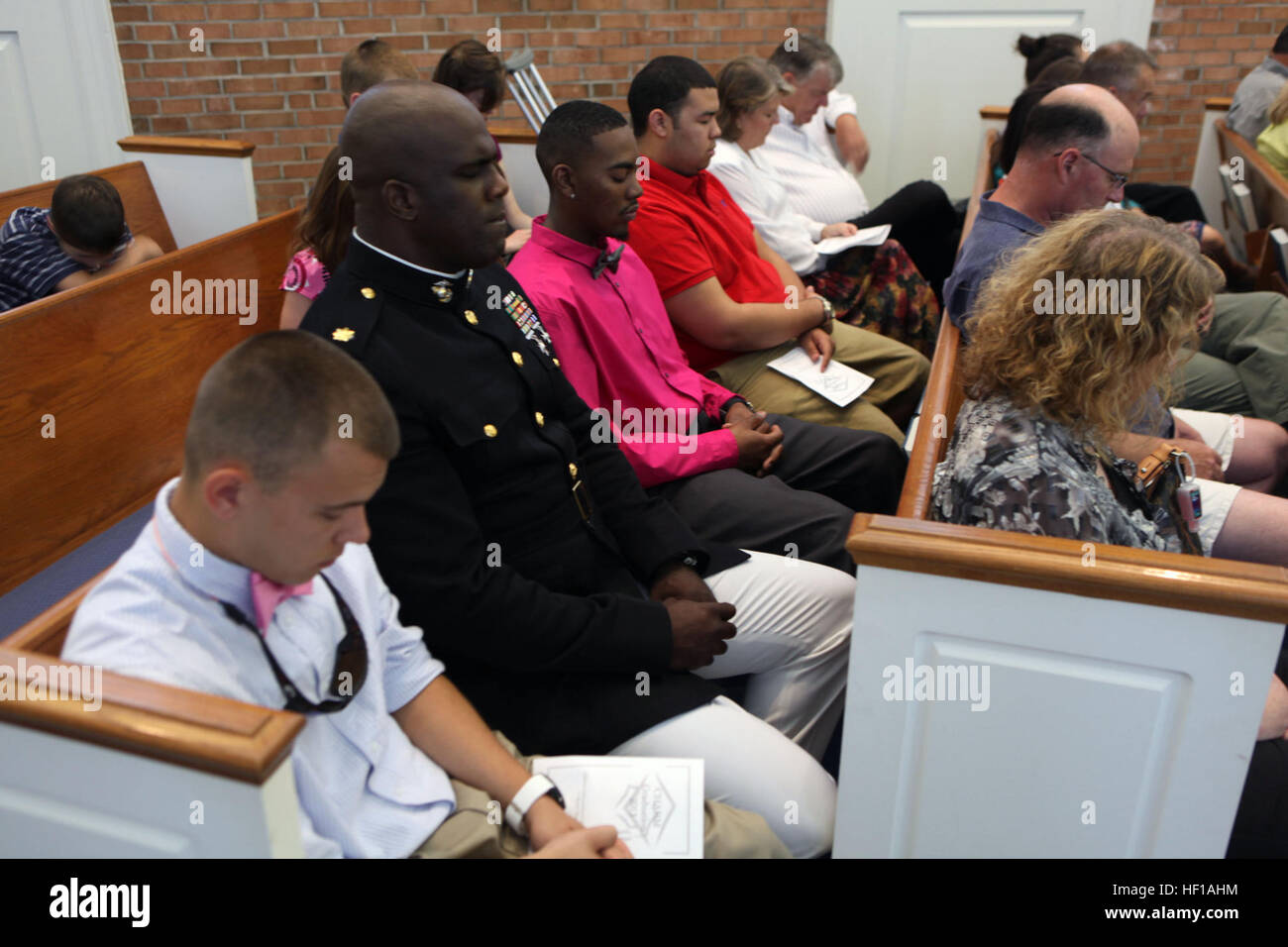 Le major LeRon E. Lane, le chef d'état-major adjoint G-6 avec 2e Groupe Logistique Maritime, ferme les yeux pendant la prière chrétienne à l'école Accueil l'obtention du diplôme de l'Association à Rocky Mount, NC, le 1 juin 2013. Lane est venu à l'obtention du diplôme pour regarder Steven C. James diplôme après avoir reçu cinq chirurgies cardiaques de son vivant. Un coeur de lion, la détermination de l'aire marine de 130601-M-AR522-015 Banque D'Images