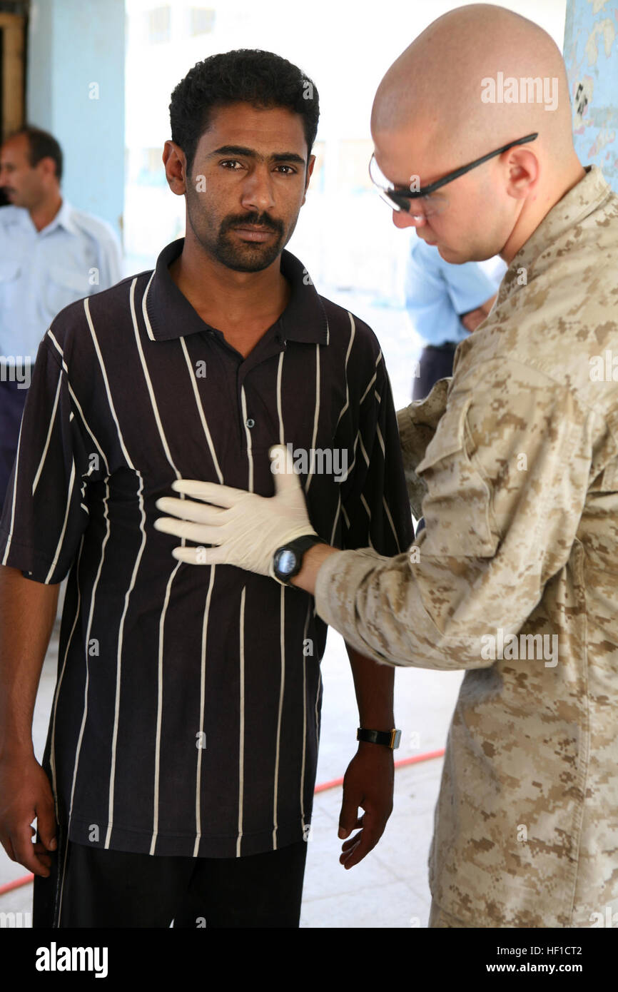 070609-M-6412C-018 Al Fallujah, Iraq (9 juin 2007) - Une marine avec la police corpsman Fallujah Équipe de transition, l'équipe de combat régimentaire 6, un contrôle d'une police irakienne potentiels recruter pour des problèmes médicaux au cours du processus de demande. La police irakienne organisent une campagne de recrutement afin d'augmenter la quantité de policiers dans les rues de Fallujah. L'équipe de combat régimentaire 6 est déployé avec les Forces-West dans la province d'Al-Anbar à l'Iraq de mettre les forces de sécurité irakiennes, faciliter le développement de la règle de droit, grâce à des réformes démocratiques, et poursuivre l'élaboration d'un marke Banque D'Images