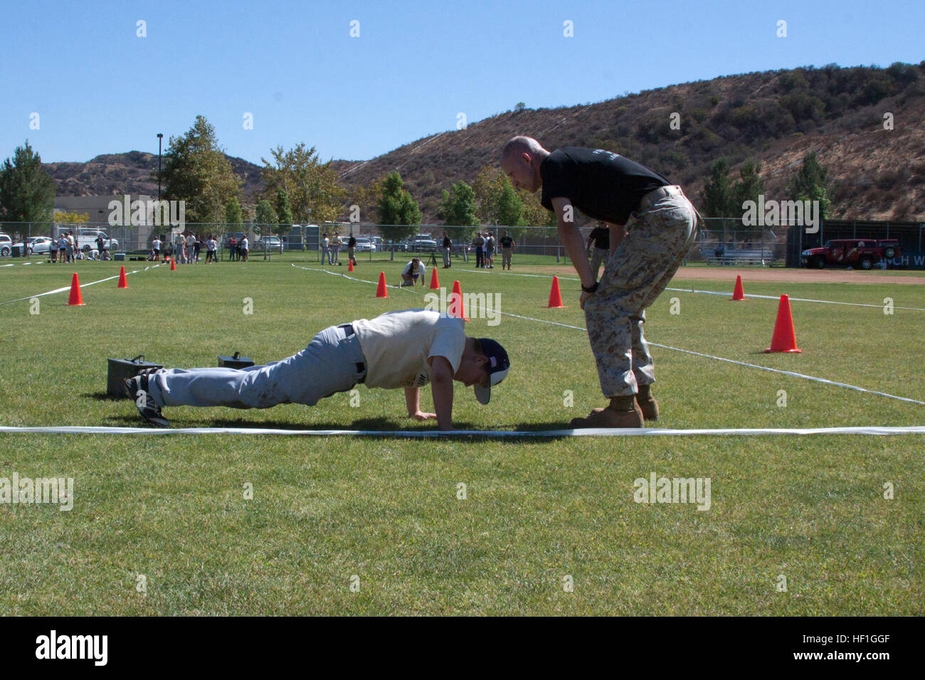 Un joueur de baseball avec West Ranch High School effectue des push-ups au cours de la manœuvre sous le feu partie de la remise en forme de combat test sur son terrain de baseball à Santa Clarita, Californie, le 1er octobre. Los Angeles de recrutement mise en place d'un CFT pour le baseball et softball joueurs à l'école secondaire. Les élèves du secondaire prendre plus difficiles de l'année d'essai, FT 131001-M-AH293-060 Banque D'Images