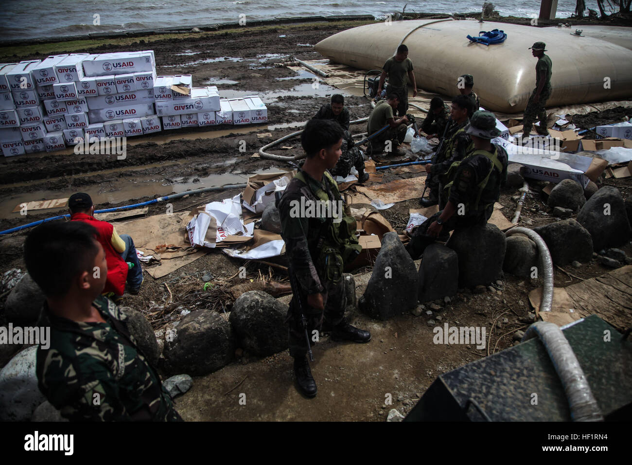 Les membres de la Police nationale des Philippines d'une force d'action spéciale de recueillir l'eau d'un système de purification de l'eau à l'atterrissage MacArthur Parc National Memorial le 21 novembre lors de l'opération Damayan. Le typhon Haiyan a frappé les Philippines le 7 novembre avec des vents soutenus estimée à près de 200 km/h et des rafales près de 230 mph. Près de 1 800 tonnes de fournitures ont été livrées, dont plus que 17 500 personnes ont été évacuées de la provinces touchées lors de l'opération. Système de purification constitue une resource 131121-M-GX379-056 Banque D'Images