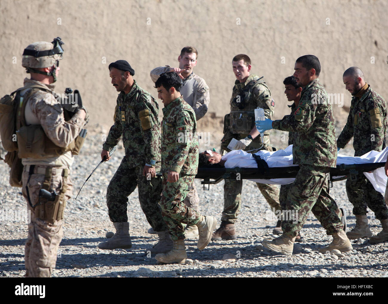 Maître de 3e classe Kristopher Krysa, centre, 27, à partir de la Grange Park, Illinois, une force de sécurité avec corpsman Conseiller Assistance 2-215, dirige une équipe d'évacuation sur une base de l'Armée nationale afghane près de base d'opérations avancée, Nolay, province de Helmand, Afghanistan, le 28 janvier 2014. Krysa a récemment été sélectionné comme le Commandement régional (Sud-ouest) et Général de Brigade Group-Afghanistan SFAAT Marin Junior du trimestre. Brute 'Doc' former, conseiller, aide le personnel médical Afghan 140128-M-PF875-300 Banque D'Images