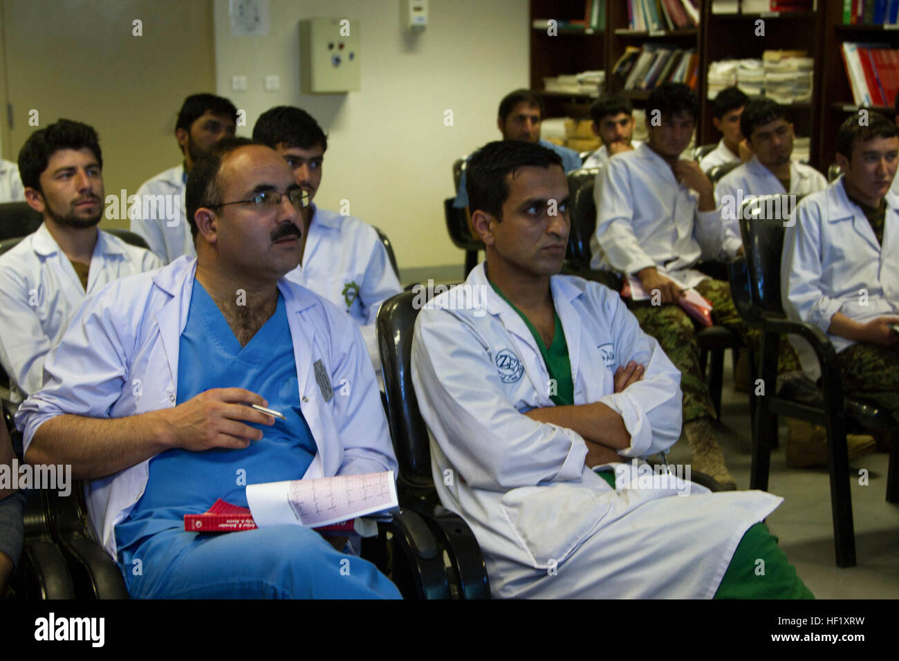 Lieutenant-colonel. Mohammed Sadiq (à gauche), chirurgien en chef de l'hôpital militaire régional de Kandahar, écoute une classe qui est donné sur l'électrocardiographie au Camp Hero, Afghanistan, le 11 février 2014. La classe a été donné par deux membres de l'Organisation du Traité de l'Atlantique Nord l'Unité médicale multinationale de rôle 3 qui a enseigné la classe en tant que partie d'un partenariat entre l'éducation et la MMU, KRMH. (U.S. Photo de l'armée par le Cpl. Mariah Meilleurs) formation EKG apporte sa confiance pour KRMH 140211 personnel-Z-TF878-680 Banque D'Images