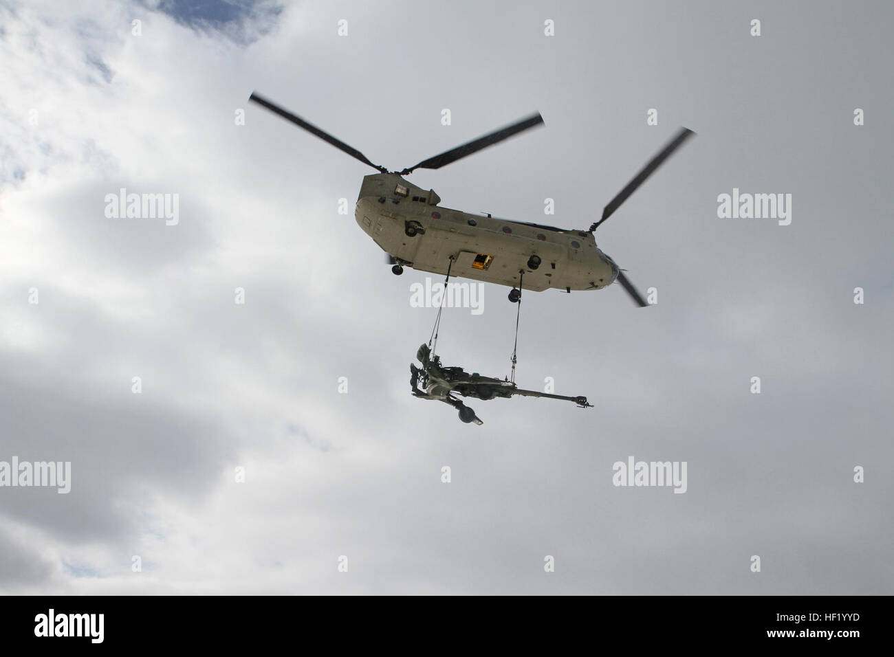 Un obusier M177 155mm est transportée par un CH-47 Chinook par temps froid, les opérations de charge de l'élingue au Camp Grayling Centre mixte, au Michigan, le 1 mars 2014. Michigan (photo de la Garde nationale par le sergent. Kimberly Bratic/libérés) Michigan Garde nationale mène la charge sous élingue par temps froid et l'exercice de tir réel d'obusiers 140301-LE-Z308-031 Banque D'Images