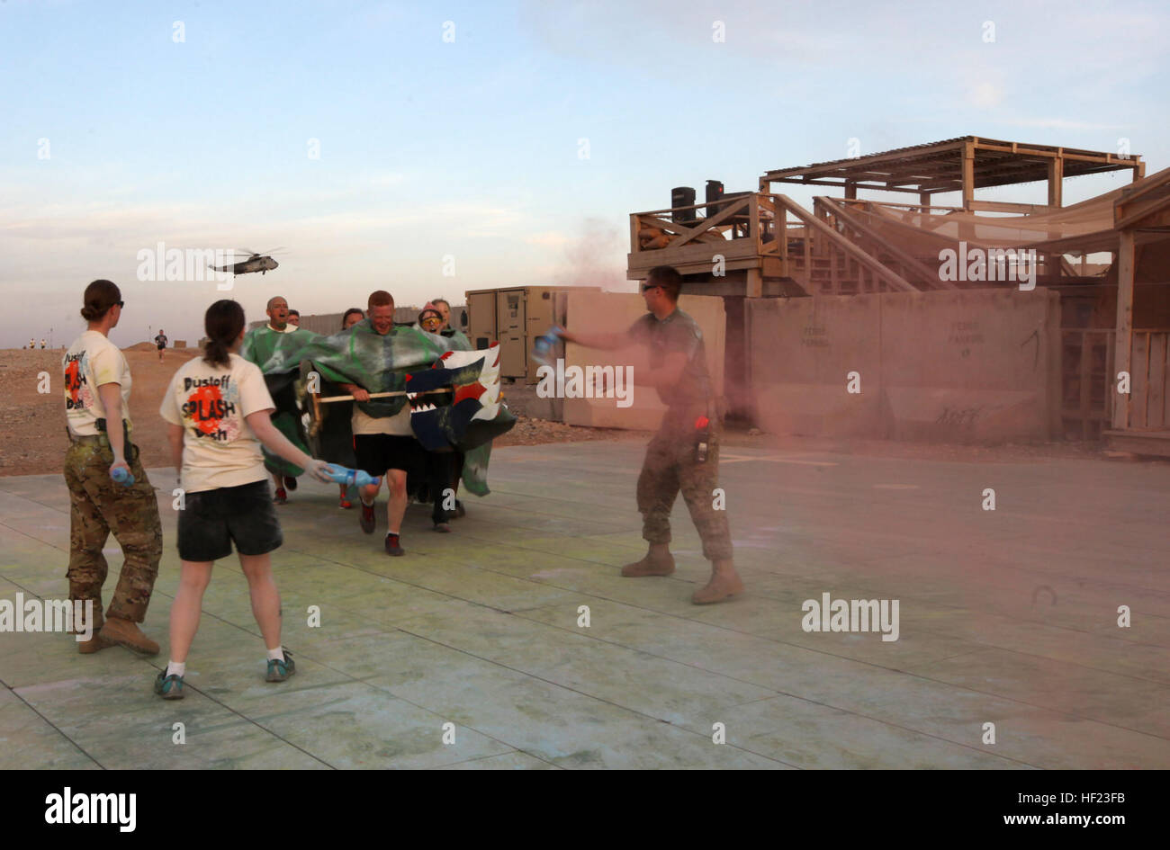 Une équipe de course en costume d'accolades d'être éclaboussé de couleur lorsqu'ils remplir un autre 1 kilomètres de tour pendant le 'Splash' Dustoff Dash 5K à bord le Camp Bastion, l'Afghanistan, le 19 avril, 2014. L'escadron d'évacuation médicale connue sous le nom de "ustoff» a organisé une course de 5 km pour les militaires à bord de Bastion et Camps Sapadalure pour apporter un peu de plaisir et de soulagement du stress pour les forces de coalition du Commandement régional (Sud-ouest). Les participants ont été encouragés à s'habiller en costumes et accessoires pour l'exécuter et sortir à établir de bons rapports. L'USMC (Photo : Sgt. Frances Johnson/libérés) Dustoff Splash Dash Banque D'Images