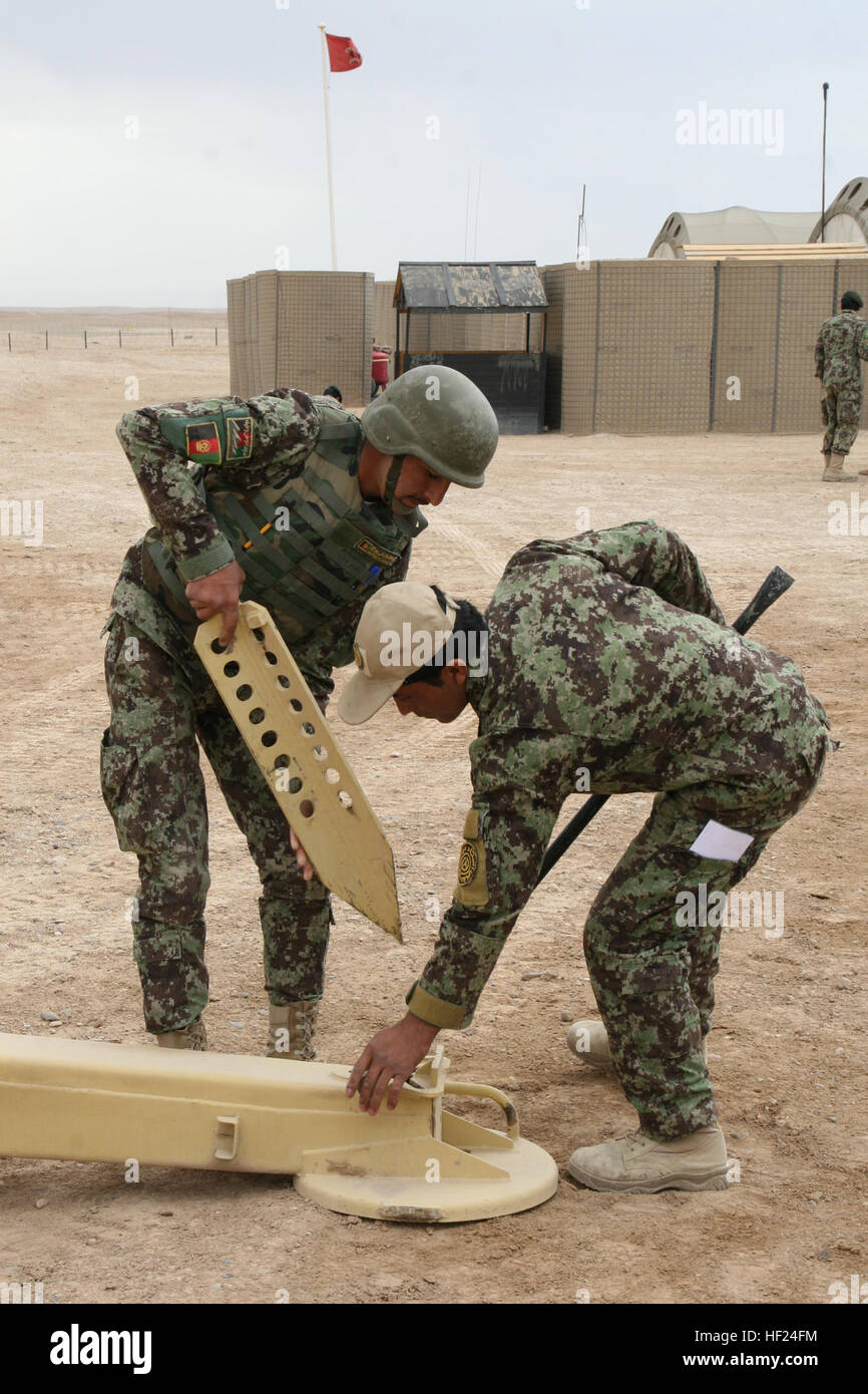 Les soldats de l'Armée nationale afghane avec le 215e Corps canadien utilisent de gros piquets métalliques pour fixer le D-30 122 mm Howitzer durant la formation à bord le Camp Bastion, dans la province d'Helmand, en Afghanistan, le 7 mai 2014. La formation fait partie d'un cours de six semaines a enseigné à l'École de combat du Corps régional qui donne les instructeurs afghans la possibilité de former leurs collègues soldats sur l'obusier système d'armes. Les trains régionaux École de combat de corps de soldats de l'Armée nationale afghane sur l'obusier d'exploitation 140507-M-KC435-003 Banque D'Images