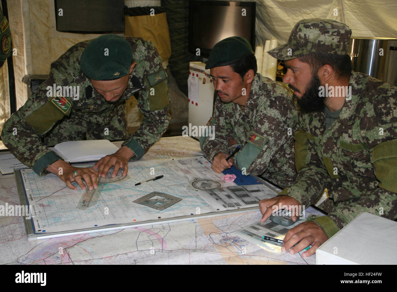 Les soldats de l'Armée nationale afghane avec le 215e Corps canadien calculer les informations reçues de l'avant des observateurs à l'entrée avec exactitude les données correctes pour l'actionnement de l'obusier de 122 mm D-30 au cours de la formation à bord le Camp Bastion, dans la province d'Helmand, en Afghanistan, le 7 mai 2014. La formation fait partie d'un cours de six semaines a enseigné à l'École de combat du Corps régional qui donne les instructeurs afghans la possibilité de former leurs collègues soldats sur l'obusier système d'armes. Les trains régionaux École de combat de corps de soldats de l'Armée nationale afghane sur l'obusier d'exploitation 140507-M-KC435-005 Banque D'Images