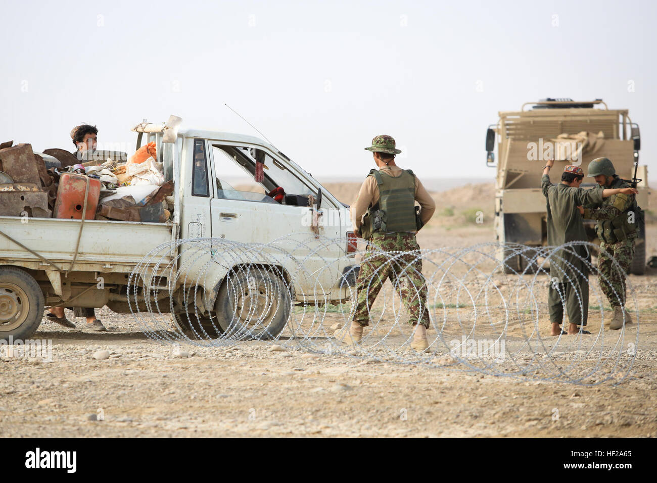L'Armée nationale afghane (ANA) ont, affecté à la 4e, 6e Kandak Tolay, 6e Brigade, 215e Corps, effectuer un contrôle des véhicules (VCP) dans le village Shekasteh Tappeh, province de Helmand, Afghanistan, le 14 juillet 2014. Soldats de l'ANA conduite VCP pour perturber l'activité de l'ennemi, de maintenir une présence militaire, et d'accroître la sécurité. (Official U.S. Marine Corps photo par Lance Cpl. Darien J. Bjorndal, Marine Expeditionary Brigade/ Afghanistan HELMAND) Parution-4ème Carmina fonctionne VCP, 140714-M-MF313-194 Banque D'Images