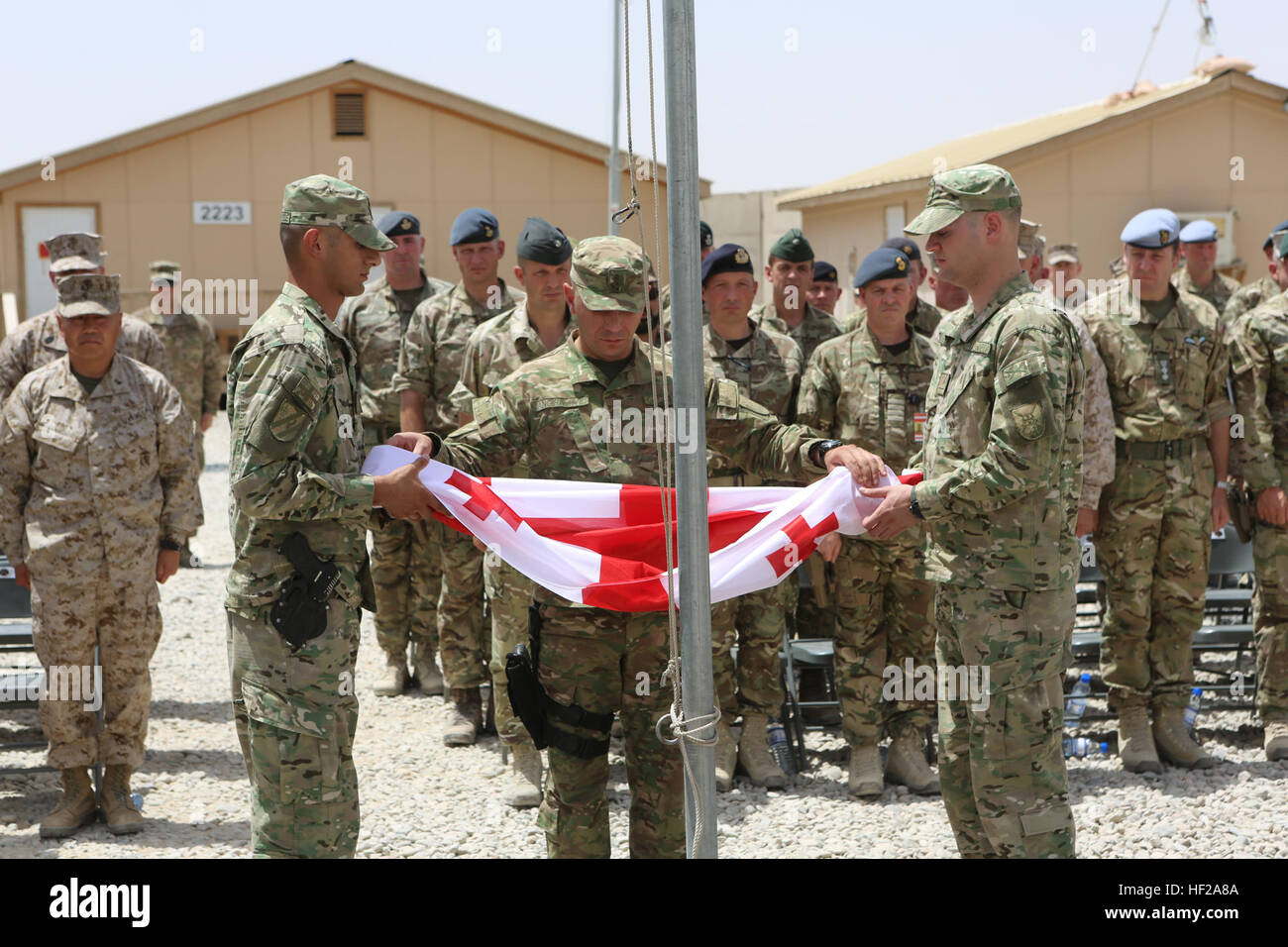 Soldats géorgiens, avec le contingent géorgien en Afghanistan, participer à la cérémonie de l'abaissement du drapeau géorgien Camp à bord Sapadalure, province de Helmand, Afghanistan, le 15 juillet 2014. L'abaissement de la partie géorgienne Flag plus Camp Sapadalure conclut officiellement la participation du pays dans le Commandement régional (Sud-ouest), depuis 2004. (Official U.S. Marine Corps photo par le Sgt. James D. Pauly, Marine Expeditionary Brigade Afghanistan/libérés) Cérémonie de descente du drapeau géorgien 140715-M-OM358-102 Banque D'Images