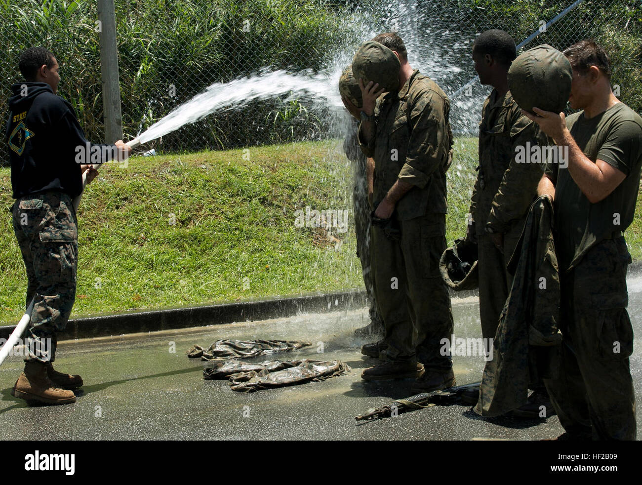 Corpsmen et aviateurs sont pulvérisés avec de l'eau pour nettoyer la boue accumulée 20 juillet après les cours d'Endurance de combat, l'épreuve finale de la Jungle Combat médecine cours à la Jungle Warfare Training Center sur Camp Gonsalves. Les corpsmen enduré quatre milles d'obstacles et navigué dans des situations de combat simulé dans la jungle du terrain. Les membres du service sont également utilisé pour se rafraîchir après exécution du cours pendant des heures dans le soleil d'Okinawa. Les corpsmen avec 3e bataillon sont dentaires et 3e Bataillon Médical, tant en 3e Groupe Logistique Maritime, III Marine Expeditionary Force ; ainsi que 1s Banque D'Images