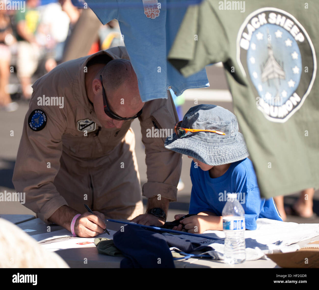 Le major du Corps des Marines américain Robert Reighnol, Marine Attack Squadron 214 (VMA-214), des autographes une affiche à bord de l'Oregon 2014 International Air Show à Portland, OR., le 20 septembre 2014. VMA-214 participe à l'Airshow de mettre en valeur les capacités des aviateurs militaires formés. (U.S. Marine Corps Photo par le Cpl. Conner Robbins / Relâché) Oregon International Air Show 140920-M-PL003-171 Banque D'Images