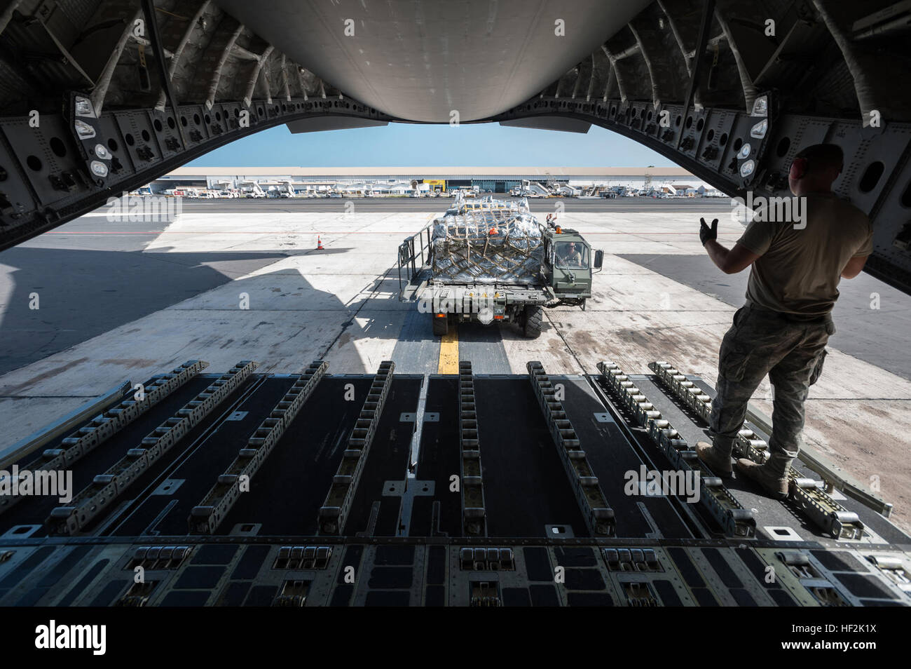 Aviateurs du Kentucky Air National Guard's 123e groupe le Plan d'intervention à partir de palettes de fret de déchargement d'un C-17 Globemaster III, affecté à la 60e Escadre, de mobilité aérienne Travis Air Force Base, en Californie, dans le cadre d'opérations de la rampe à l'aéroport International Léopold Sédar Senghor de Dakar, Sénégal, le 18 octobre 2014, à l'appui de l'opération United de l'aide. Les aviateurs sont l'exploitation d'une base d'étape intermédiaire à Dakar pour acheminer l'aide humanitaire et militaire cargo dans les zones touchées, travaillant de concert avec les soldats de l'armée américaine 689th Port rapide de l'ouvrant, un personnel Inscrivez-vous Banque D'Images