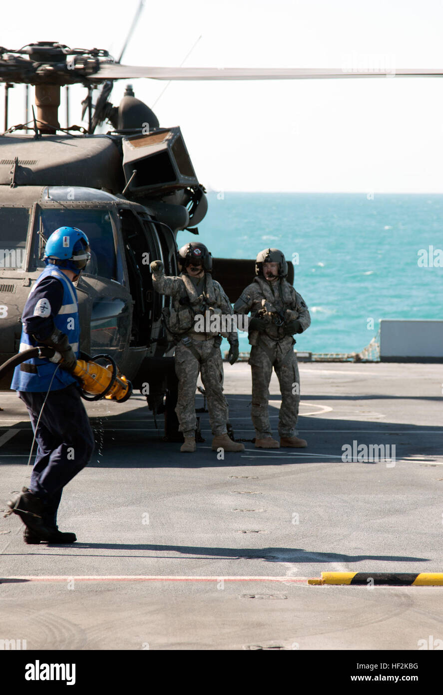 Les membres de l'équipage de l'hélicoptère d'assaut 2-147, bataillon déployé avec la 34e Brigade d'aviation de combat au Koweït, attendre à bord de la Royal Fleet Auxiliary Baie de Lyme dans le Golfe arabe, en tant que membre de la Marine royale britannique se prépare à leur carburant UH-60 Black Hawk le 22 octobre 2014. Des équipages d'de la compagnie B et C Company, 2-147e AHB, ont été évalués et qualifiés à la terre le Black Hawk sur le pont d'un navire pour les missions futures. (Minnesota Army National Guard photo de 1er Lieutenant Holly Elkin/libérés) qualification appontage 141022-Z-QD498-809 Banque D'Images