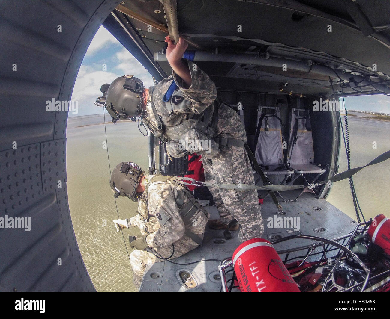 Le Sgt. A.J. Harrelson (assis) et le Sgt. Chris Renaud observer un nageur de sauvetage et "victime" de leur "UH-60 Black Hawk" sur l'hélicoptère au cours de formation en recherche et sauvetage avec Texas Task Force 1 (TX-TF1) Les soldats, qui sont membres de la 36e Brigade d'aviation de combat (cabine), 36e Division d'infanterie (Texas Army National Guard), ont effectué plusieurs jours de formation sur la côte du golfe du Mexique, près de Galveston, Texas. La 36e CAB travaille régulièrement avec TX-TF1 et est prête à répondre aux catastrophes naturelles en vertu de l'état Plan de gestion des situations d'urgence. (U.S. La Garde nationale de l'armée photo par le major Randall S Banque D'Images