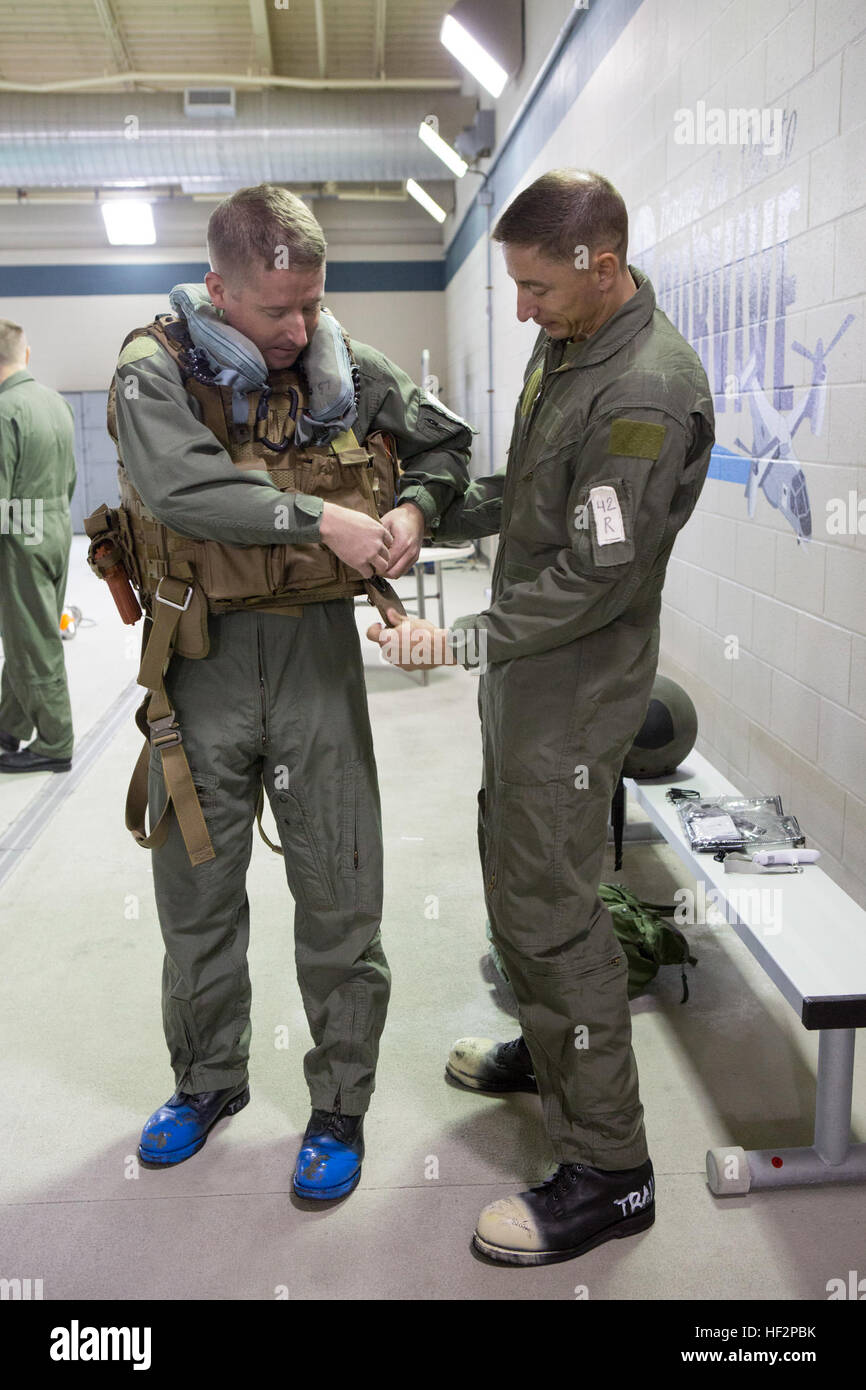 La Marine américaine HM2 Anthony J. Bartolini, droite, une sécurité aérienne affectés à l'aéronef maritime corpsman Group (MAG) 26, aide le lieutenant Gregory W. Boggs, un agent affecté à la sécurité aérienne MAG-29, accrocher une veste de survie d'endurance de l'équipage d'air pour une utilisation pendant un exercice d'entraînement à la survie en eau Marine Corps Air Station Cherry Point, N.C., 8 décembre 2014. L'exercice a été réalisée afin de se familiariser avec les marins de l'équipement de sécurité. (U.S. Marine Corps photo par le Cpl. Yosselyn A. Munnerlyn/libérés) Exercice d'entraînement de survie en eau 141208-M-OB177-015 Banque D'Images