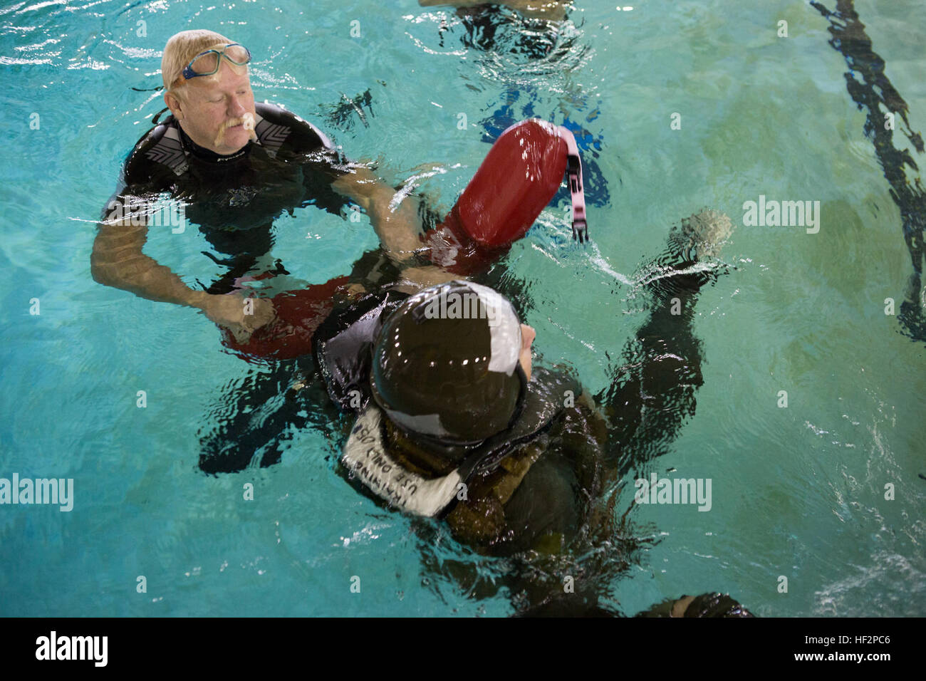 Richard A. Turner, à gauche, un instructeur de survie de l'eau affectée à la survie de l'Aviation Centre de formation de la Marine américaine, les escortes Le Lieutenant Gregory W. Boggs, un agent affecté à la sécurité aérienne des aéronefs maritimes Groupe 29, à côté de la piscine pendant un exercice d'entraînement à la survie en eau Marine Corps Air Station Cherry Point, N.C., 8 décembre 2014. L'exercice a été réalisée afin de se familiariser avec les marins d'équipage de l'endurance vestes de survie. (U.S. Marine Corps photo par le Cpl. Yosselyn A. Munnerlyn/libérés) Exercice d'entraînement de survie en eau 141208-M-OB177-073 Banque D'Images