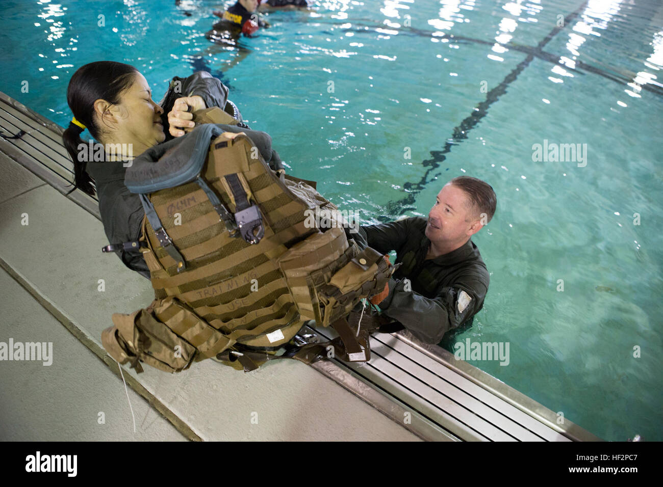 Le lieutenant de la Marine américaine Maile L. Richert, gauche, un agent affecté à la sécurité aérienne des aéronefs Marine Group (MAG) 26, reçoit une équipe de l'air veste de survie d'endurance du lieutenant Gregory W. Boggs, un agent affecté à la sécurité aérienne MAG-29, au cours d'un exercice d'entraînement à la survie en eau Marine Corps Air Station Cherry Point, N.C., 8 décembre 2014. L'exercice a été réalisée afin de se familiariser avec les marins de l'équipement de sécurité. (U.S. Marine Corps photo par le Cpl. Yosselyn A. Munnerlyn/libérés) Exercice d'entraînement de survie en eau 141208-M-OB177-076 Banque D'Images