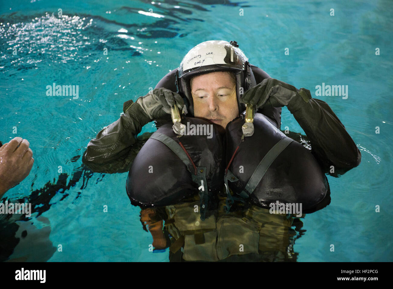 Le lieutenant de la Marine américaine Gregory W. Boggs, un agent affecté à la sécurité aérienne des aéronefs maritimes Groupe 29, se gonfle d'air une endurance de l'équipage la veste de survie au cours d'un exercice d'entraînement à la survie en eau Marine Corps Air Station Cherry Point, N.C., 8 décembre 2014. L'exercice a été réalisée afin de se familiariser avec les marins de l'équipement de sécurité. (U.S. Marine Corps photo par le Cpl. Yosselyn A. Munnerlyn/libérés) Exercice d'entraînement de survie en eau 141208-M-OB177-123 Banque D'Images