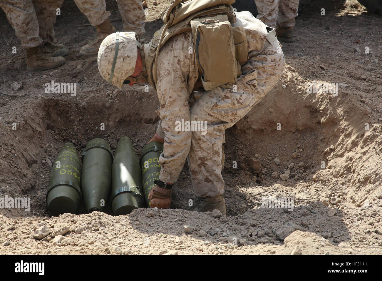 Le Cpl. Joshua J. Syverson, ingénieur de combat avec Peloton de génie, administration centrale et Service Company, élément de Combat Force intégrée, les lieux M107 de 155 mm de haut projectiles explosifs dans le sol au cours d'une réduction de la mémoire cache de l'essai pilote à distance 114, Marine Corps Air Ground Combat Center Twentynine Palms, California, le 3 mars 2015, en préparation de la Marine Corps Test de fonctionnement et d'évaluation l'évaluation de l'activité. À partir de Octobre 2014 à juillet 2015, le GCEITF sera conduite au niveau individuel et collectif dans la formation professionnelle des armes de combat au sol désigné spécialités dans o Banque D'Images