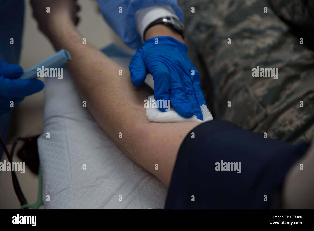 Un technicien de laboratoire supprime l'aiguille d'un bras du donneur au cours d'un don de sang le 19 mars, à l'Armé du Commandement du Pacifique de la banque de sang des Services Center, U.S. Naval Hospital Okinawa, Camp Foster, Okinawa, Japon. La banque de sang pour sang fournit l'ensemble de la zone d'opérations et PACOM est pris en charge par les dons d'accord de statut des forces américaines à Okinawa (personnel Marine Corps Photo par Lance Cpl. Janessa K. Pon/ libéré) PACOM Armed Services Centre de la banque de sang inaugure les nouvelles installations 150318-M-TA471-137 Banque D'Images