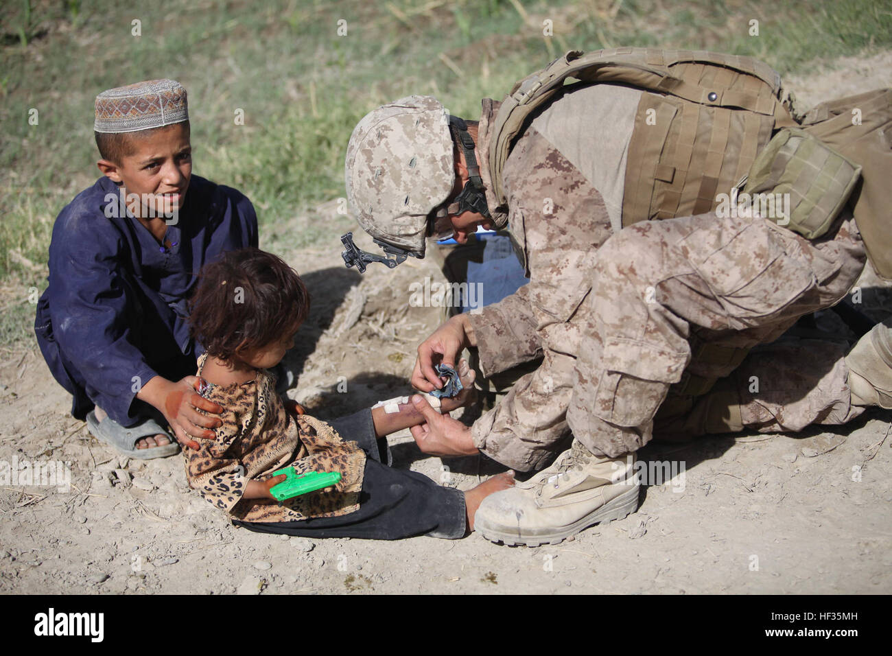 090717-M-0440G-087 la province d'Helmand, en Afghanistan (17 juillet 2009) Hospital Corpsman 2e classe Brian Sandau traite une fille afghane pour brûlures sur sa jambe au cours d'une patrouille du Groupe des affaires civiles avec les Marines du 1er Bataillon, 5e Régiment de Marines, et des militaires de l'Armée nationale afghane dans le district de Nawa de la Province d'Helmand, en Afghanistan. (U.S. Marine Corps photo par le s.. William Greeson/libérés) US Navy 090717-M-0440G-087 Hospital Corpsman 2e classe Brian Sandau traite une fille afghane pour brûlures sur sa jambe au cours d'une patrouille du groupe des affaires civiles Banque D'Images