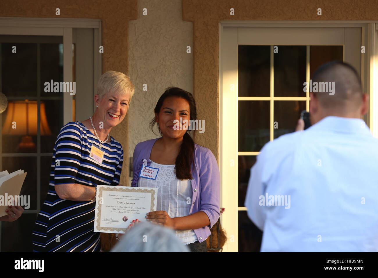 Jocelyn Valdez, étudiant, Twentynine Palms High School, serre la main d'Eileen Murray, président, les conjoints des agents' Club, après avoir reçu sa bourse lors de la bourse annuelle d'octroi de subventions et de réception à la maison du major-général Lewis A. Craparotta, lutter contre le général commandant du Centre, le 7 mai 2015. (Marine Corps photo par Lance Cpl. Ayala-Lo Medina/libérés) Bourse d'hôtes de la CVMO, octroi de subventions/150507-M-RO214-221 Banque D'Images